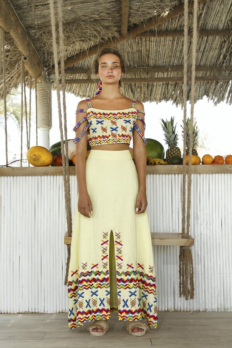 A yellow cropped top and trousers pairing is decorated with traditional zig-zag and X-shaped embroidery