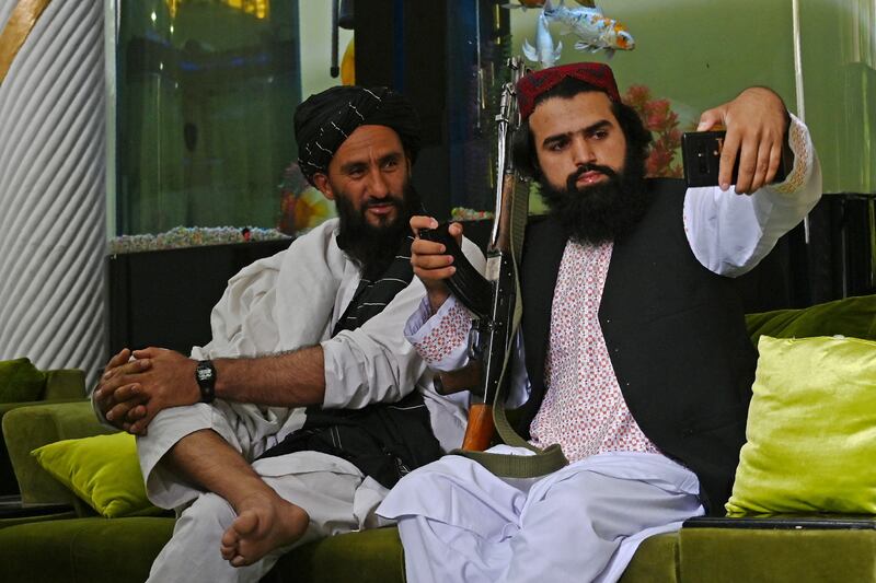 Taliban fighters take a selfie after they stormed and overran the home of the Afghan warlord Abdul Rashid Dostum in the Sherpur neighborhood of Kabul. on September 11, 2021. AFP