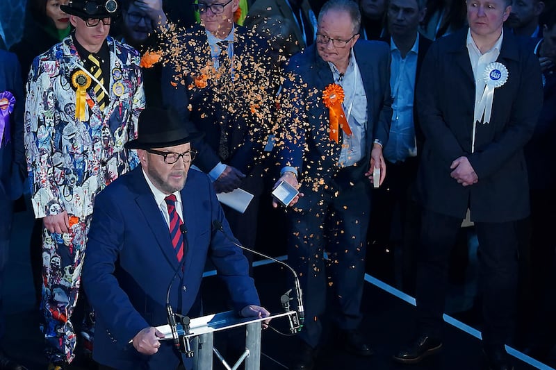 Confetti is thrown over Mr Galloway by Just Stop Oil protestors as he gives his speech after being declared winner. AP