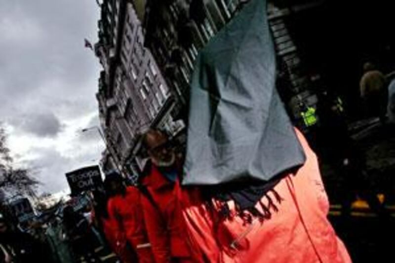 Protesters dressed as Guantanamo Bay prisoners are chained together during the Anti-War march through the streets of Central London in February 2007.