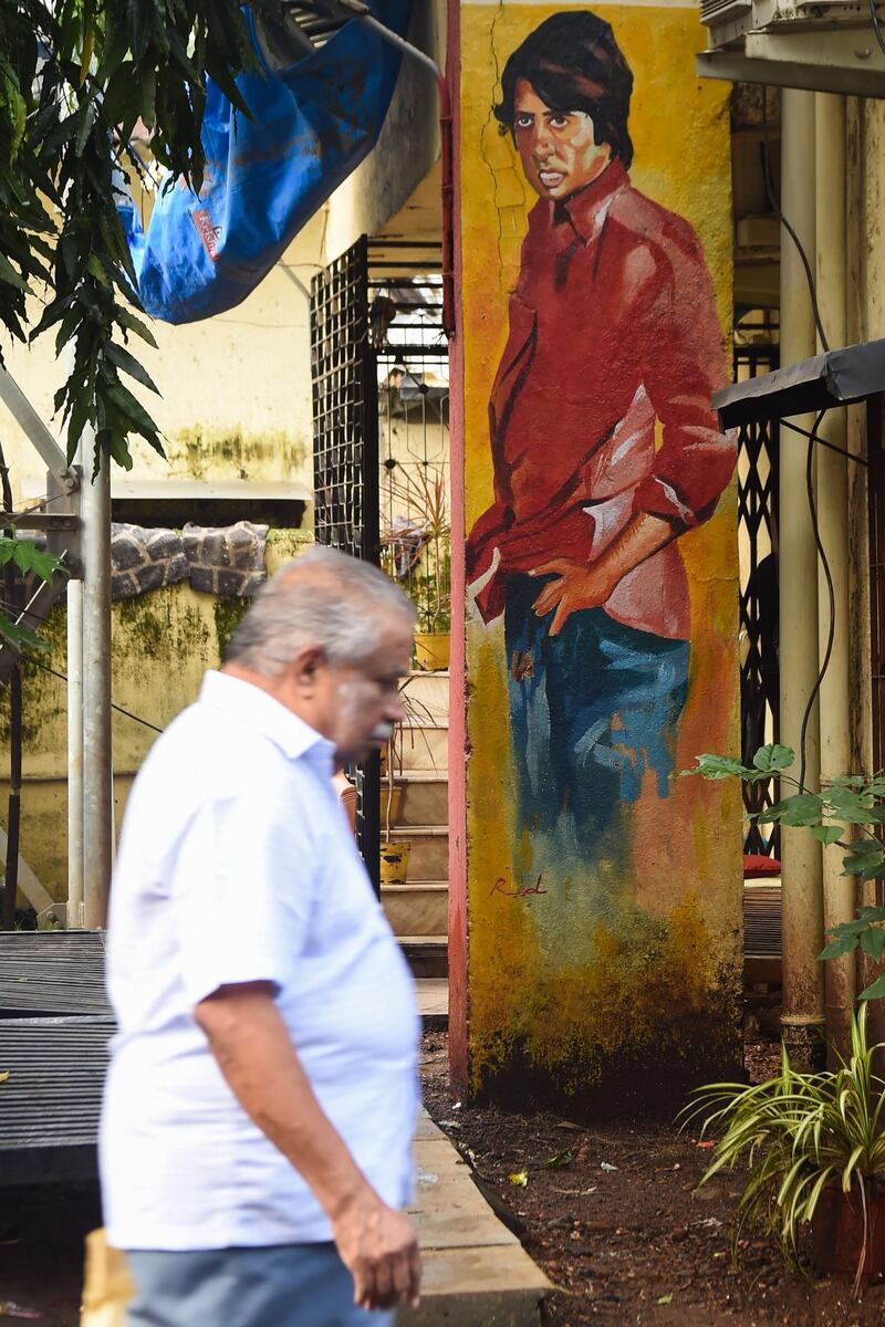 A pedestrian walks past a mural of Bollywood actor Amitabh Bachchan in Mumbai on September 16, 2019 India's "Bollywood Oscars" will rock Mumbai on September 18 after 19 years on the road with an all singing, all dancing extravaganza -- and with the industry in flux but booming. - TO GO WITH 'India-film-Bollywood' FOCUS by Vishal Manve and Bhuvan Bagga
 / AFP / Indranil MUKHERJEE / TO GO WITH 'India-film-Bollywood' FOCUS by Vishal Manve and Bhuvan Bagga
