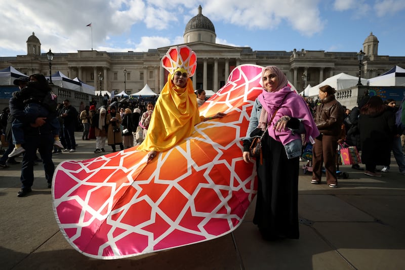 A woman poses with a performer during Eid in the Square celebrations in Trafalgar Square, London. Reuters