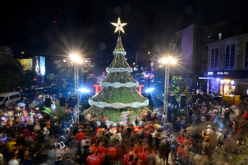 People gather around a giant Christmas tree, which has been officially lit up at the entrance of Byblos (Jbeil), Lebanon, 08 December 2022.   EPA / WAEL HAMZEH