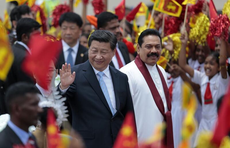 Chinese president Xi Jinping, left, waves as he walks with Sri Lankan president Mahinda Rajapaksa upon arrival at the airport in Colombo on September 16 before his visit to India for talks with Narendra Modi. Eranga Jayawardena / AP Photo