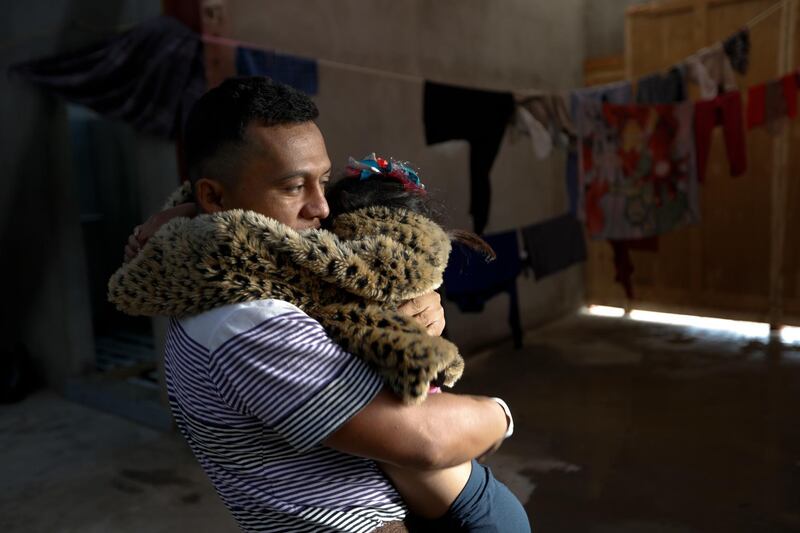 A man hugs his daughter inside a former concert venue serving as a shelter for migrants in Tijuana, Mexico. AP Photo