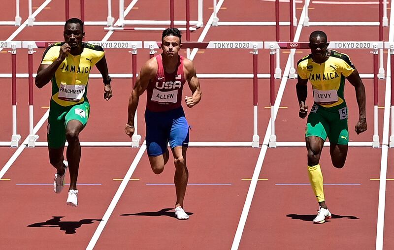 Jamaica's Hansle Parchment, left, runs to first place ahead of third-placed Jamaica's Ronald Levy, right.