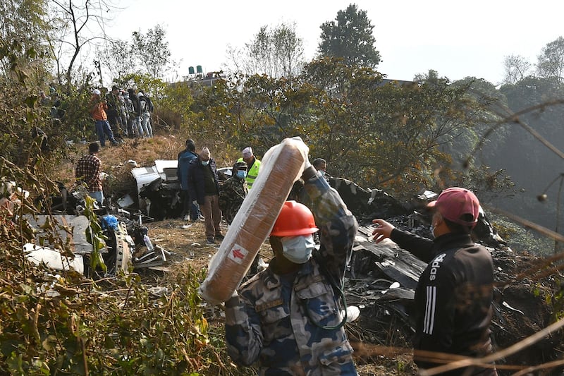 Rescuers inspect the wreckage at the site of a plane crash. AFP