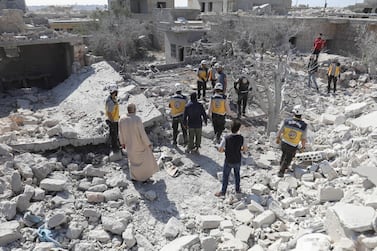 Members of the Syrian Civil Defence (White Helmets) and civilians gather following a regime airstrike on the village of Kafriya, in Syria's Idlib province. AFP