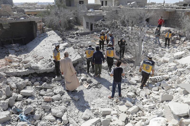TOPSHOT - Members of the Syrian Civil Defence (White Helmets) and civilians gather following a reported regime airstrike on the village of Kafriya, in Syria's Idlib province, on July 13, 2019.
 / AFP / Omar HAJ KADOUR
