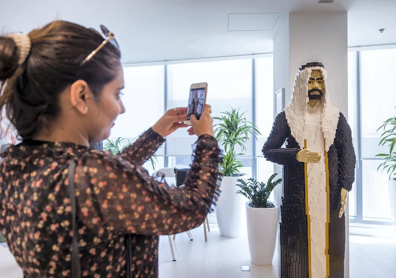 DUBAI, UNITED ARAB EMIRATES - A visitor taking photo of an Arab life size made of Lego at the opening of the new Lego office in Dubai Design District.  Leslie Pableo for The National