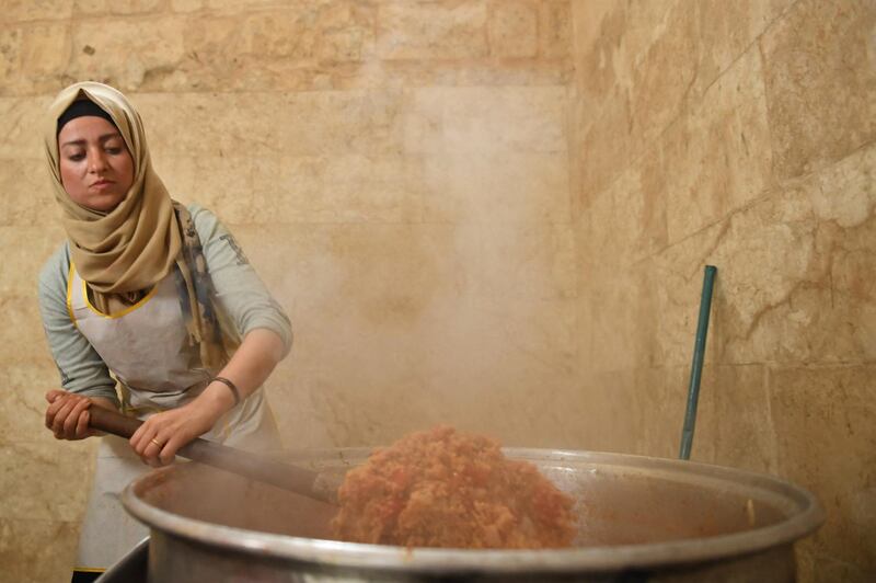 A woman from a humanitarian organisation prepares an iftar meal for the needy in Aleppo, Syria, during Ramadan. AFP