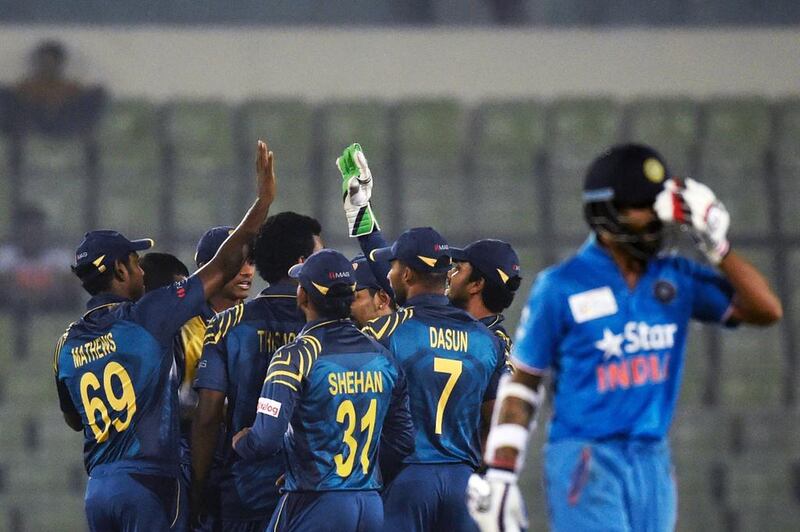 Sri Lanka players celebrate after the dismissal of India’s Shikhar Dhawan (R) during the Asia Cup T20 cricket tournament match between India and Sri Lanka at the Sher-e-Bangla National Cricket Stadium in Dhaka on March 1, 2016. / AFP / MUNIR UZ ZAMAN