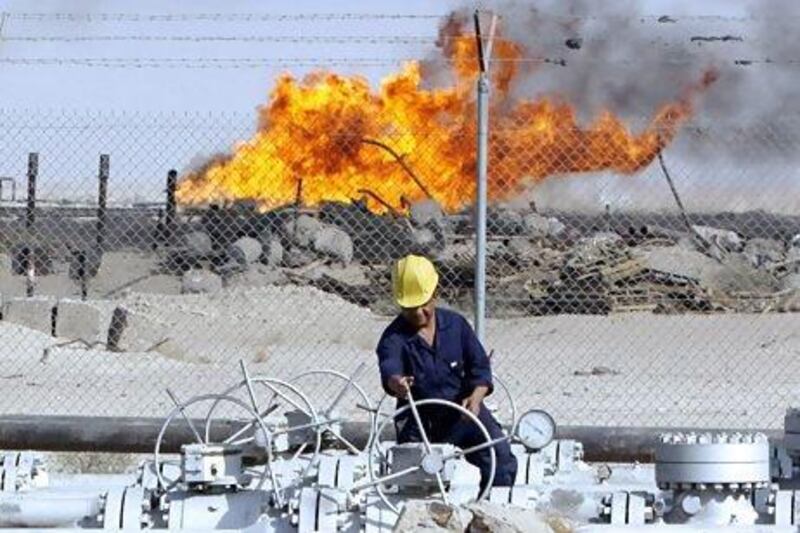 An Iraqi worker operates valves at the Rumaila oil refinery near the city of Basra.