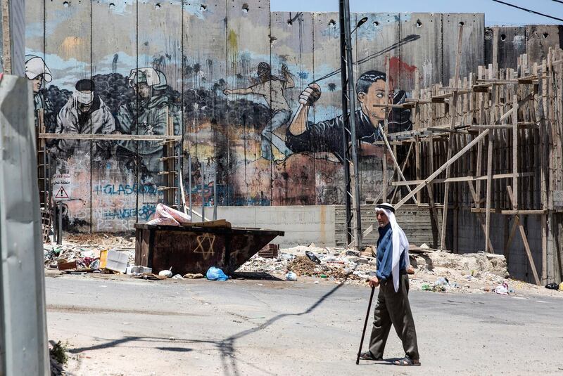 Palestinian Abdel Hadeef Abu Sul,87, walks along Israel's separation camp near his home in the Aida refugee camp in the city of Bethlehem on June 23,2019 .Photo by Heidi Levine for The National