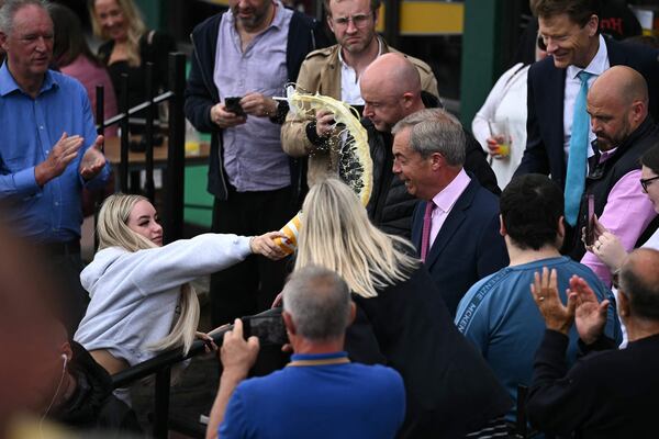 Reform UK's Nigel Farage is doused by a protester as he begins his campaign in Clacton-on-Sea, eastern England