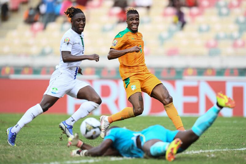 Sierra Leone goalkeeper Mohamed Nbalie Kamara makes a save with Wilfried Zaha waiting to pounce in background. AFP