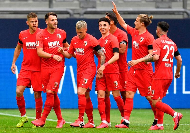 Augsburg's German midfielder Eduard Loewen, second left, celebrates with teammates after scoring his side's opening goal. AFP