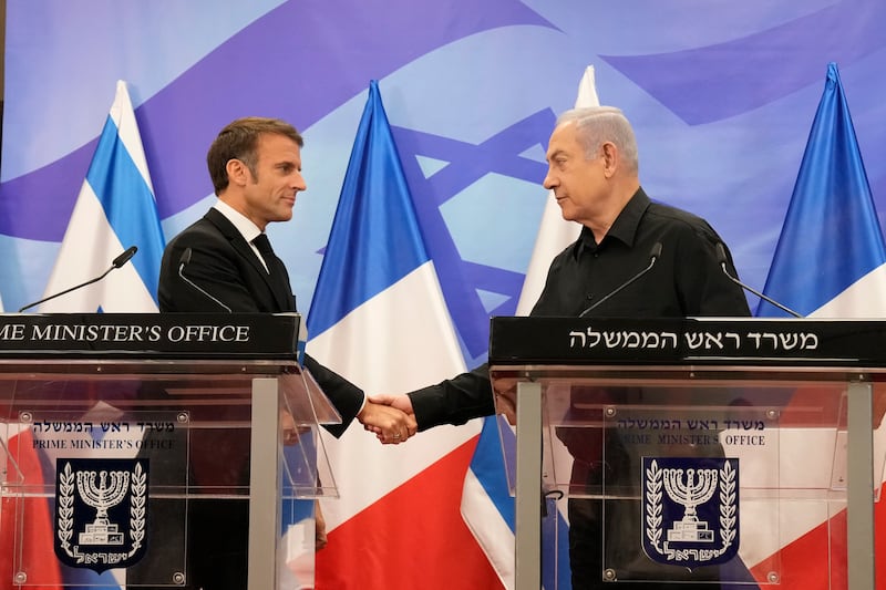 Israeli Prime Minister Benjamin Netanyahu, right, shakes hands with French President Emmanuel Macron at a press conference in Jerusalem on Tuesday. AP