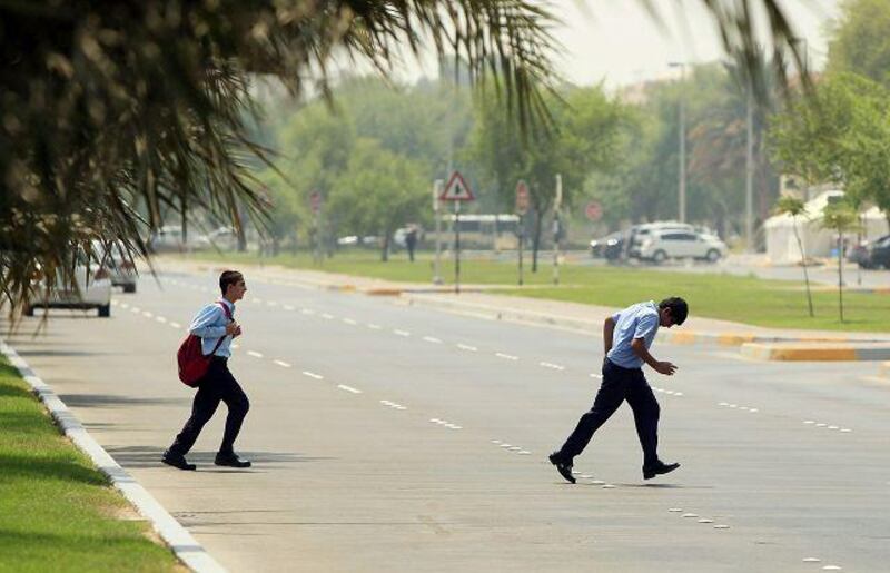 Two students from the Sheikh Khalifa bin Zayed Arab Pakistan School cross 21st Street in Abu Dhabi after school hours.