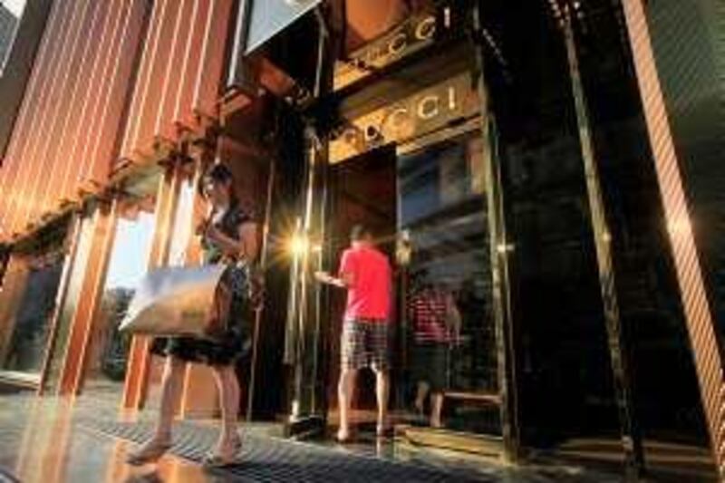 ** GO WITH STORY TITLED China Luxury Shanghai by ELAINE KURTENBACH ** A local shopper walks out from newly opened Gucci flagship shop Thursday June 25, 2009 in Shanghai, China. (AP Photo/Eugene Hoshiko)