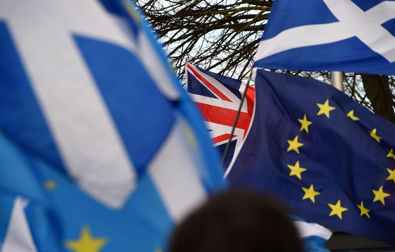 Pro-Union activists wave a Union flag (C) as Scottish Saltire and EU flags fly during an anti-Conservative government, pro-Scottish independence, and anti-Brexit demonstration outside Holyrood, the seat of the Scottish Parliament in Edinburgh on February 1, 2020.  Britain began its post-Brexit uncertain future outside the European Union on Saturday after the country greeted the historic end to almost half a century of EU membership with a mixture of joy and sadness. There were celebrations and tears on Friday as the EU's often reluctant member became the first to leave an organisation set up to forge unity among nations after the horrors of World War II. / AFP / ANDY BUCHANAN                       
