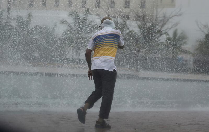 A man covers his head under heavy rain. Kamran Jebreili / AP Photo