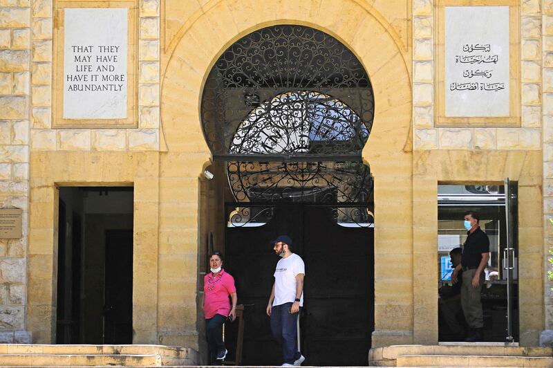 People stand at the entrance of the American University of Beirut, on June 1, 2020. - Since it was founded in 1866 by Protestant missionaries from the United States, AUB has become one of the most prestigious universities in the Middle East, producing generations of leaders, artists, and intellectuals. But AUB president says with Lebanon's economy tanking, the university is facing "perhaps its greatest crisis", and plans to dismiss up to a quarter of its 6,500-strong workforce. (Photo by JOSEPH EID / AFP)