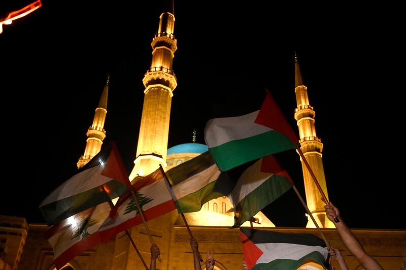 Protesters carry Palestinian and Lebanese flags during a protest to show solidarity with the Palestinians in Jerusalem and the West Bank in downtown Beirut, Lebanon. EPA