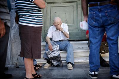 Pensioners wait to enter a National Bank of Greece SA bank branch to collect their pension payments in Athens, Greece, on Friday, July 17, 2015. Germany's Parliament is set to ratify bridge financing and the start of talks for a three-year rescue plan. Photographer: Matthew Lloyd/Bloomberg