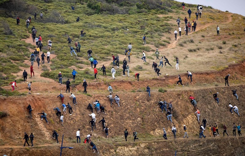 Migrants avoid the Moroccan police as they try to reach the border between Morocco and Ceuta. AFP