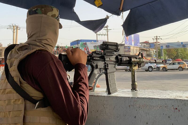 A member of the Taliban's Badri 313 military unit on guard outside the airport in Kabul.  AFP