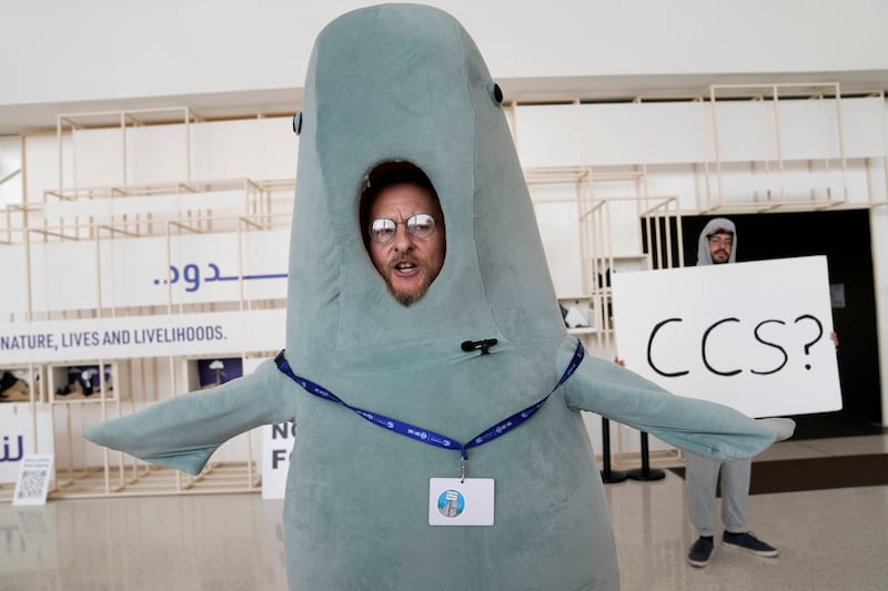 A person in a dugong costume stands near a sign that says CCS. Carbon capture and storage featured prominently in the Cop28 decision. AP