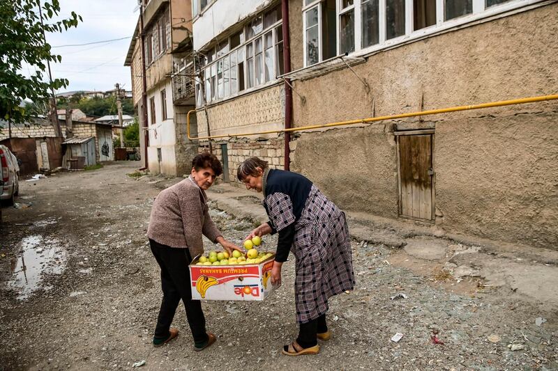 Two women carry fruits to a shelter in the city of Stepanakert, Azerbaijan on October 10, following a ceasefire during the military conflict between Armenia and Azerbaijan over the breakaway region of Nagorno-Karabakh. Aris Messinis/ AFP