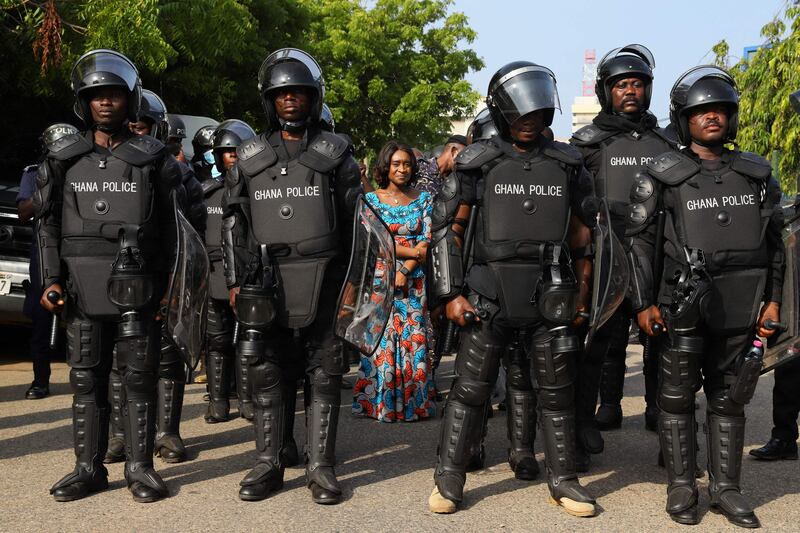 Abena Osei Asare, Ghana's Deputy Minister of Finance, is protected by the police at the ministry offices on the second day of a demonstration over soaring living costs, in the capital Accra.  AFP