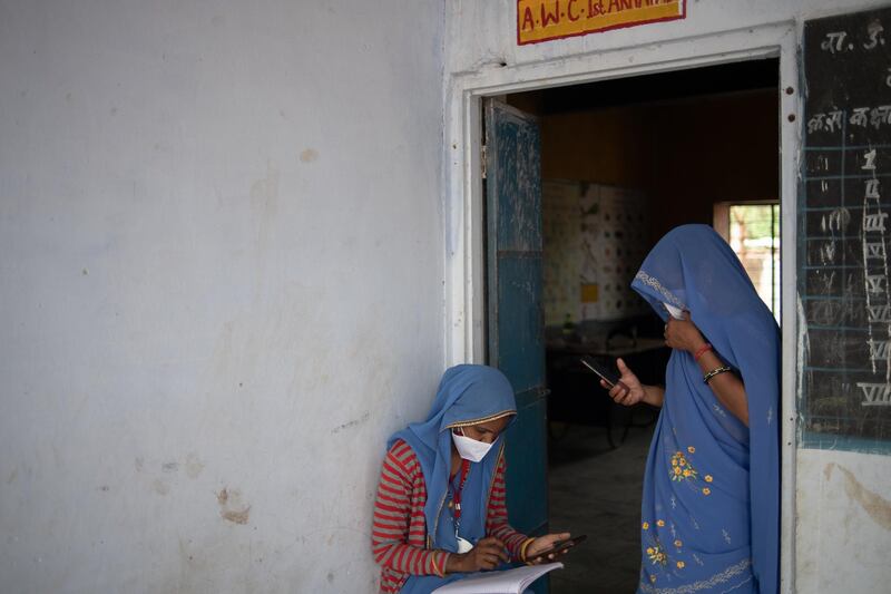 Social health activists call and register vaccine beneficiaries ahead of the start of a vaccination clinic to administer the Covaxin vaccine in Aakhtadi, Tonk District, Rajasthan. Getty Images