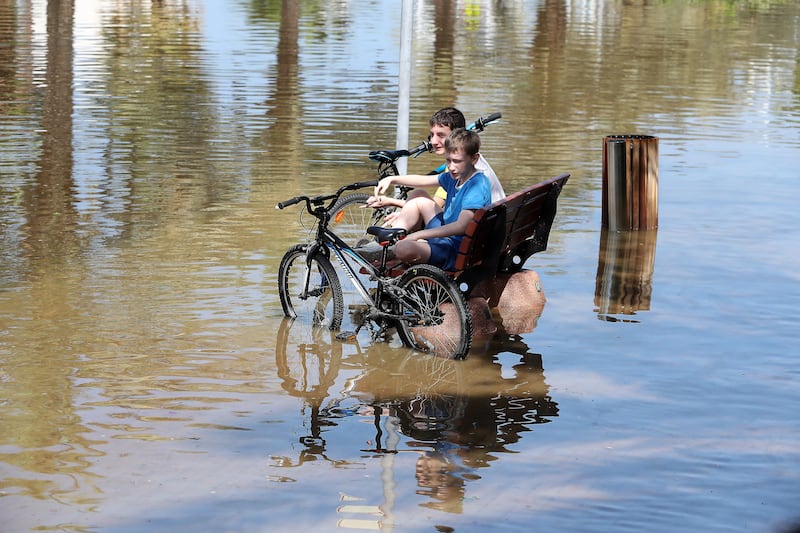 Children with their bicycles in the flooded streets of Al Furjan. Pawan Singh / The National