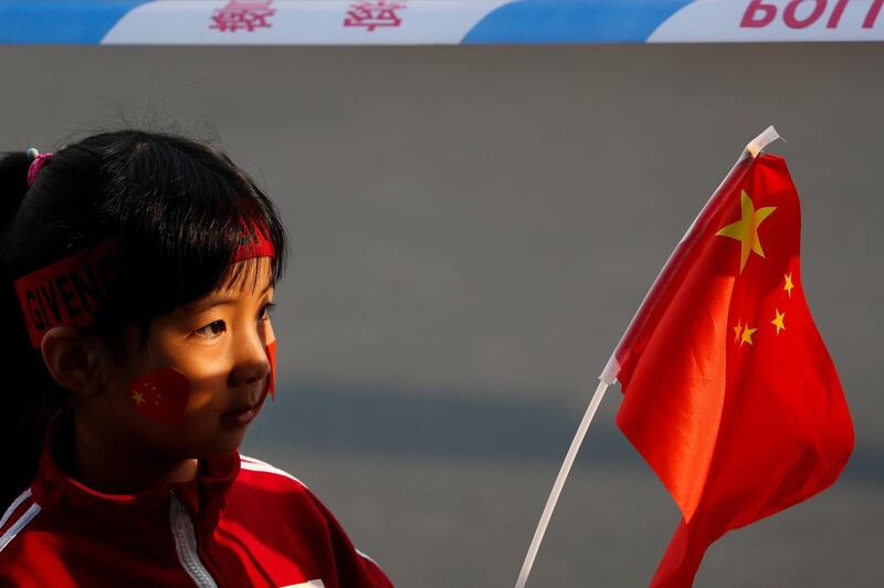 A child waves a national flag in Beijing. AP