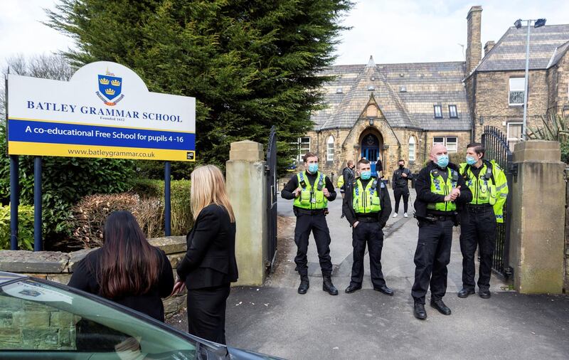 Police positioned outside the school gates. Angry parents are protesting outside a Batley Grammar School, West Yorks, after a teacher allegedly showed derogatory caricatures of the Prophet Muhammad, pictured in West Yorks, March 25 2021.  See SWNS story SWLEprotest.