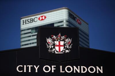 HSBC's building in Canary Wharf is seen behind a City of London sign outside Billingsgate Market in London, Britain, August 8, 2018. REUTERS/Hannah McKay