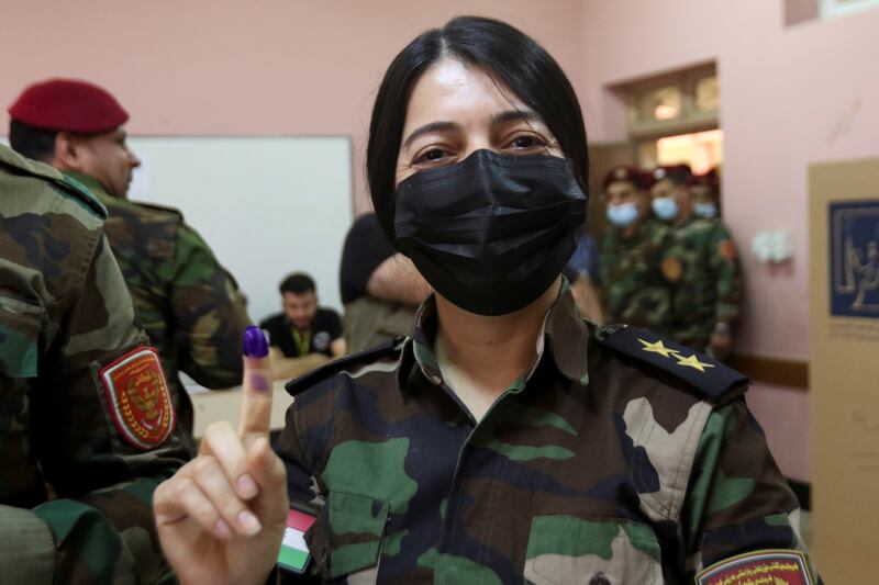 A member of Kurdish Peshmerga military forces shows her ink-stained finger after voting in a special process on October 8, 2021 in Erbil, two days before Iraq's parliamentary elections. Reuters