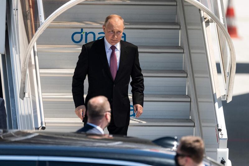 Mr Putin steps down from his plane at Geneva Airport. AFP