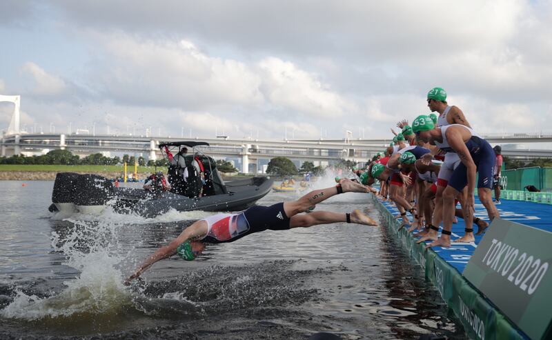 Athletes dive on a false start to the Olympic triathlon.