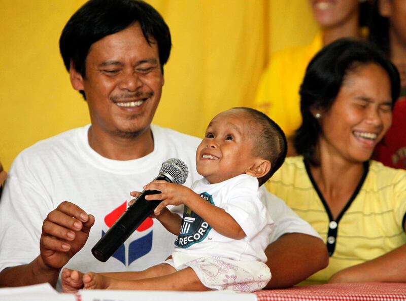 Reynaldo, left, and Concepcion Balawing, parents of Junrey Balawing, center, 18, react as Junrey jokes on the microphone after he was officially declared 'the world's shortest living man' by the Guinness World Records at Sindangan Municipal Hall, Sindangan township, Zamboanga Del Norte province in Southern Philippines, Sunday June 12, 2011. Balawing was officially declared 'the world's shortest living man' with a measurement of 59.93 Centimeters (23.5 inches) dislodging Nepal's Khagendra Thapa Magar with a measurement of 26.4 inches. (AP Photo/Bullit Marquez) *** Local Caption ***  XBM108_Philippines_Shortest_Man.jpg
