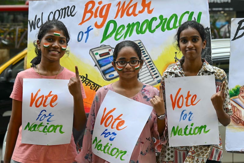 Art school students pose with posters illustrating the upcoming India's parliamentary elections, in Mumbai on Saturday. AFP