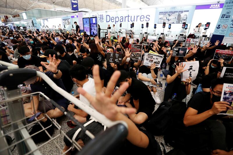 Anti-government protesters react after the announcement that all airport operations are suspended due to a demonstration at Hong Kong Airport on August 13, 2019. Reuters