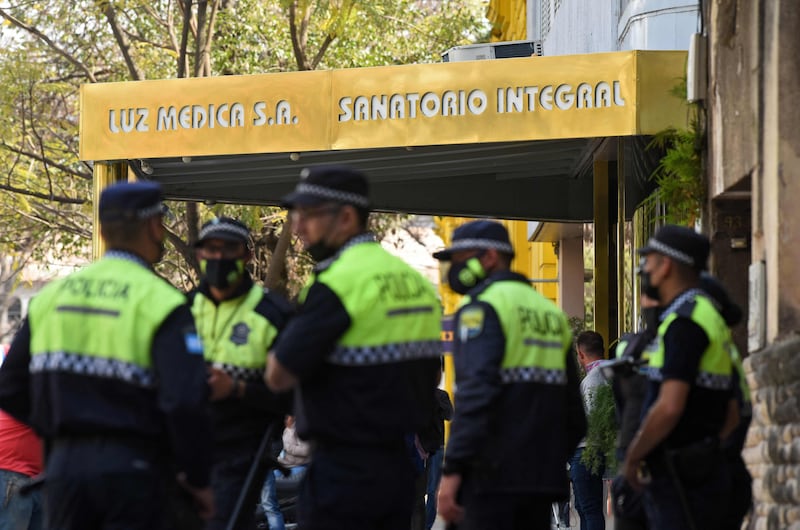 This picture released by Telam shows police officers standing at the entrance of the Luz Medica hospital, where nine people infected with bilateral pneumonia of unknown origin have been treated, in Tucuman, Argentina, on September 1, 2022. AFP