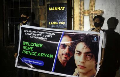 Fans of Bollywood superstar Shah Rukh Khan hold a poster outside his house, Mannat, after his eldest son Aryan was granted bail by the Bombay High Court. Reuters