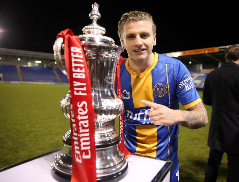 Shrewsbury Town's Jason Cummings poses next to the FA cup trophy. Reuters