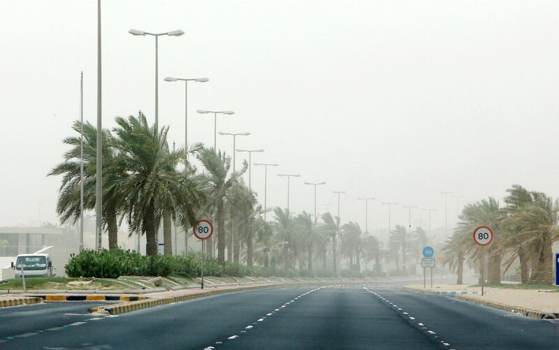 Palm trees sway in the wind during a dust storm in Kuwait City. AFP