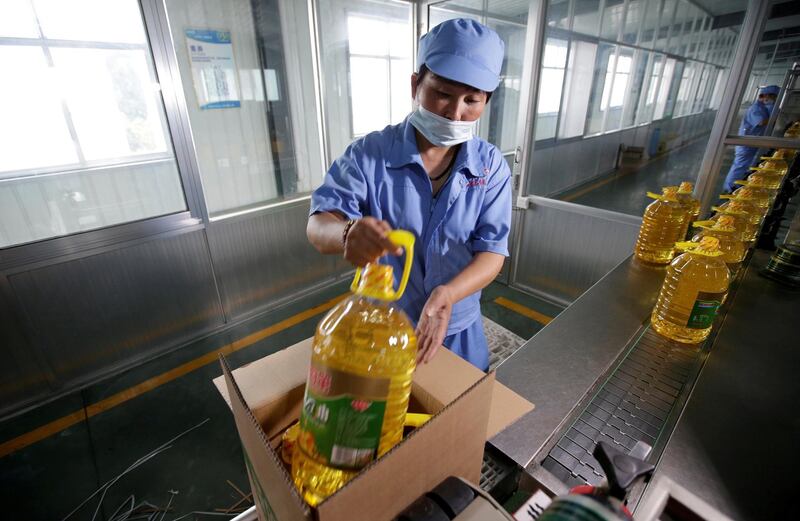 FILE PHOTO: A worker packs bottles of soybean oil made from the U.S. imported soybeans at the plant of Liangyou Industry and Trade Co., Ltd in Qufu, Shandong province, China July 4, 2018. REUTERS/Jason Lee/File Photo